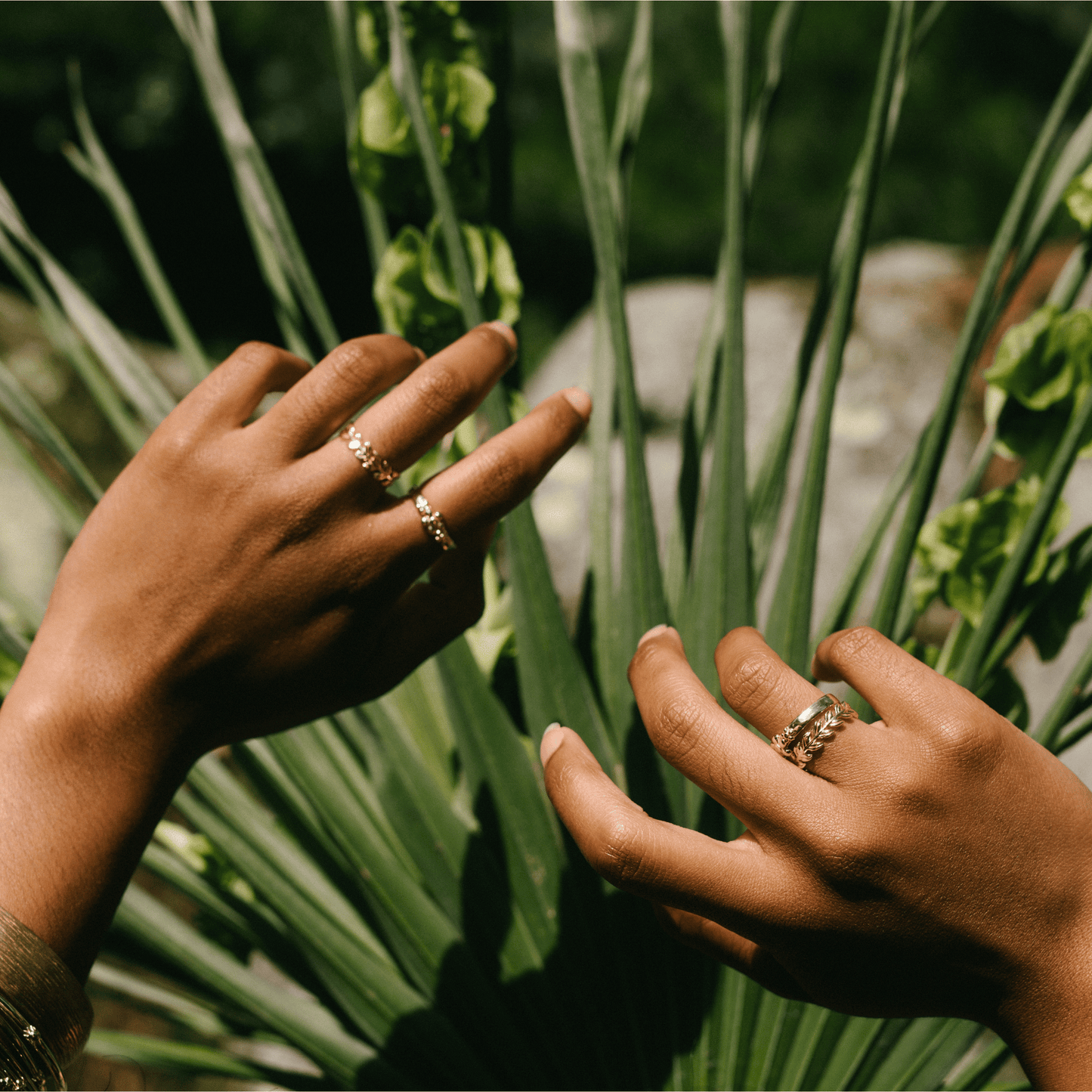 A golden band and other jewelry on the hand of a woman.