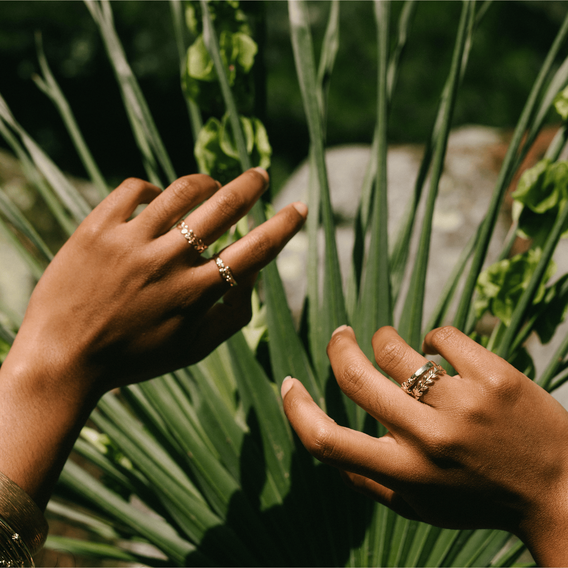 A golden band and other jewelry on the hand of a woman.