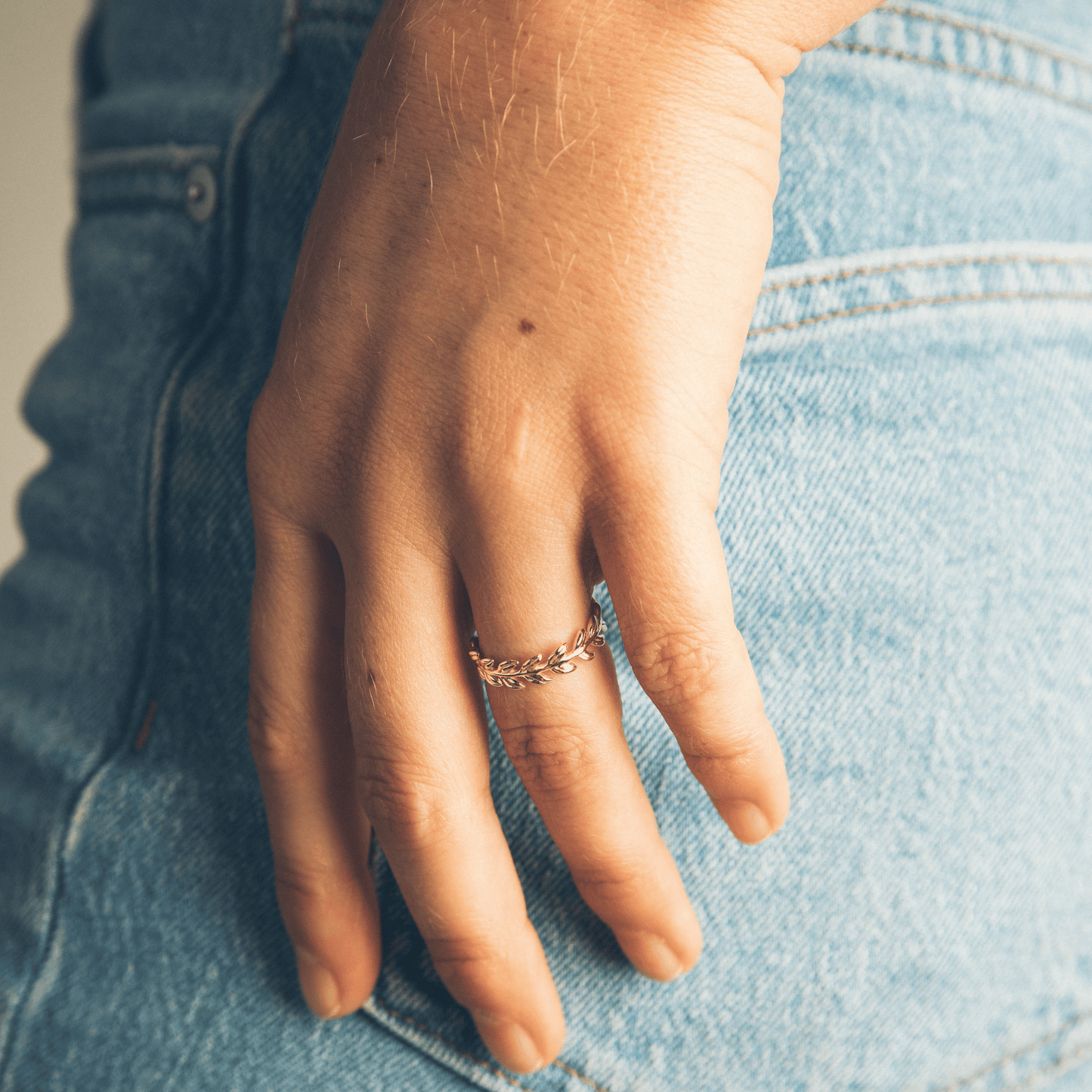 The queen of the forest ring on a woman's hand with hands in pockets.