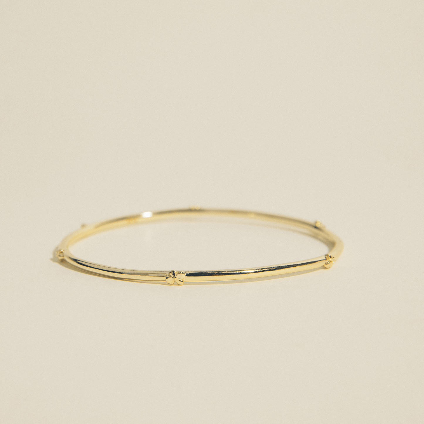 The hydrangea bangle is a thin golden bangle adorned with hydrangea flowers.