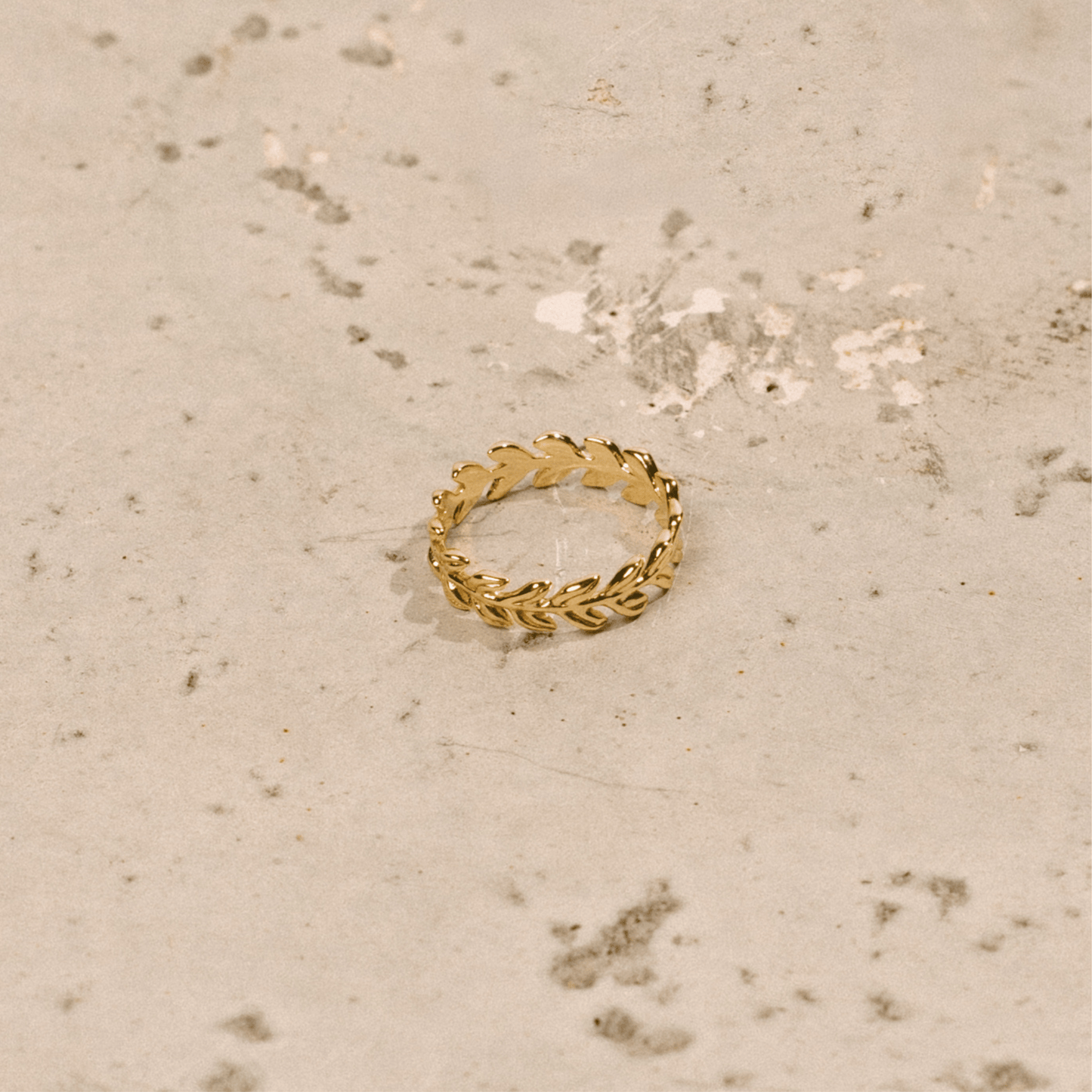 The crown of leaves ring is a golden band shaped like a laurel crown.