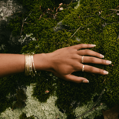 A hand on a mossy forest background, clad in the Frida ring